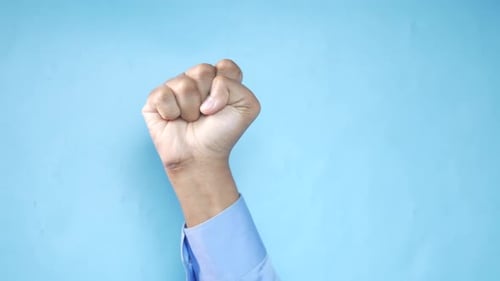 Clenched Fist Against Blue Background