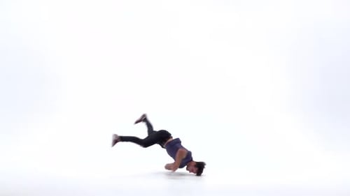 Man tanzt Breakdance auf weißem Hintergrund in schlichtem grauem T-Shirt und grauen Jeans. Zeitlupe