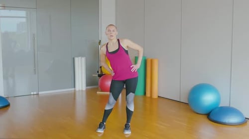 Woman in Workout Gear Bends and Stretches
