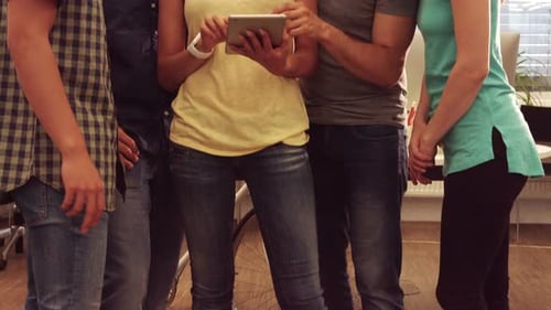 Diverse Team Collaborating on Tablet in Modern Office