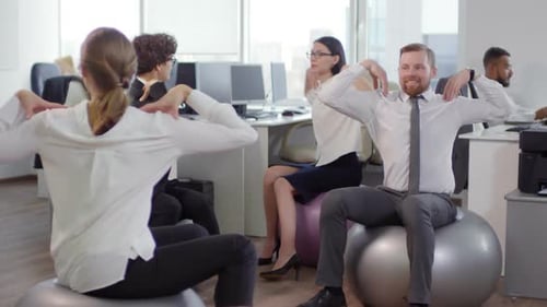 Office Workers on Fitness Balls Doing Stretching Exercises