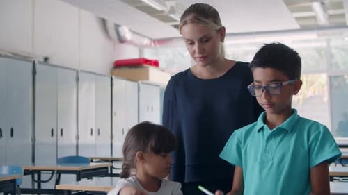Friendly Female School Teacher Watching Pupils