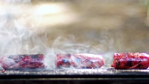 Sausages Sizzling on a Grill with Smoke