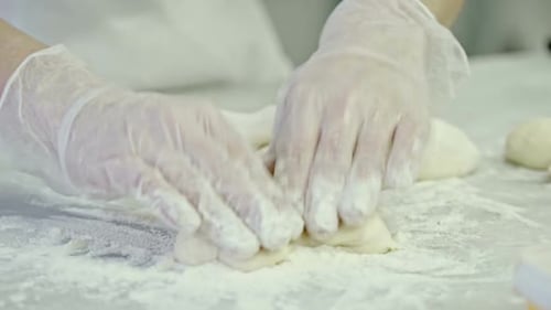 Dough Being Shaped by Gloved Hands Close Up
