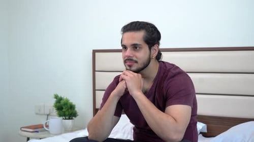 Young Man Thinking Deeply in Bedroom