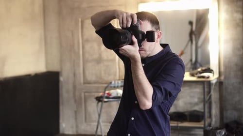 A Young Male Photographer Is Photographing a Model in the Studio.