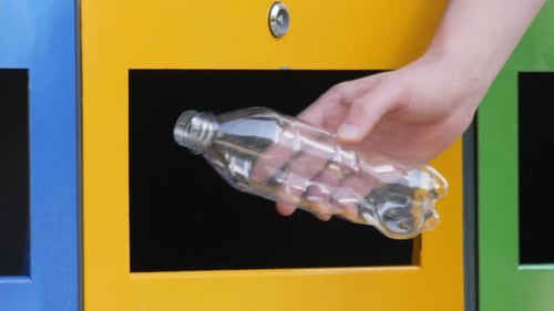 Hand Recycles Plastic Bottle in City Bin