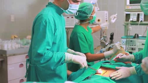 Side view of a surgical team next to a patient