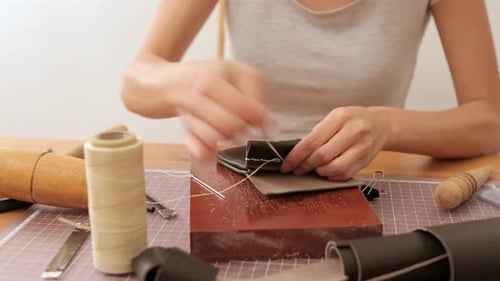 Woman Hand Sewing Leather Project on Table