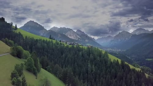 Fliegen Sie über ein kleines Bergdorf in den Dolomiten in Italien