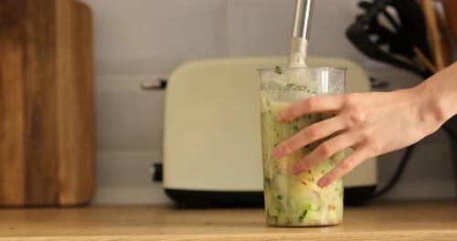Making Fresh Green Smoothie with Blender in Kitchen
