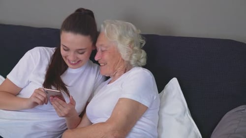 Young Woman and Senior Woman Laughing at Phone