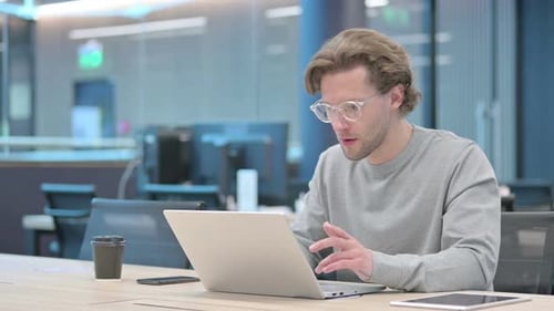 Man Cheers at Computer in Modern Office