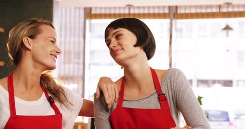 Two waitresses standing together in cafe