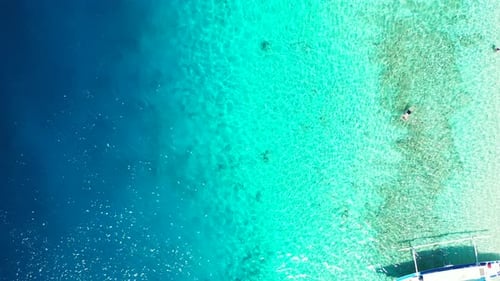 Beautiful sea texture with boats floating over blue turquoise lagoon and people swim on crystal emer