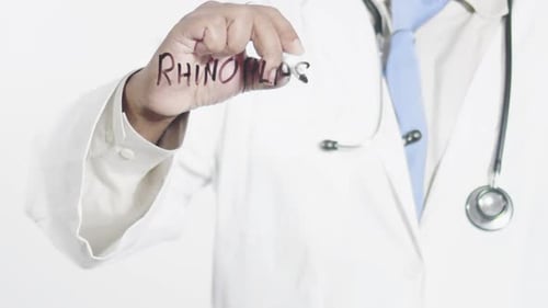 Doctor Writing Rhinoplasty on Transparent Surface