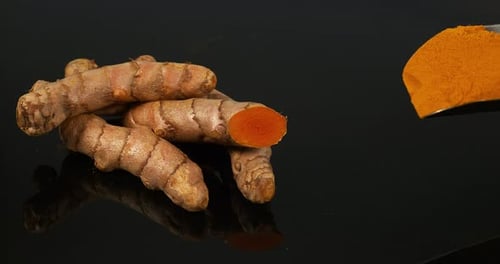 Turmeric, Turmeric Longa, Roots and Powder on Black Background, Indian Spice, Slow Motion 4K
