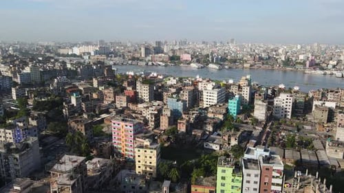 Aerial flight over populous city of Dhaka; view of boat traffic on Buriganga river - drone flight fo
