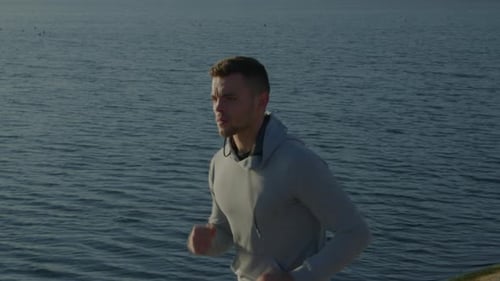 Young Slim Man In Hoodie Is Running