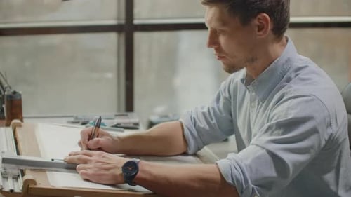 Architect Drawing Blueprints in Modern Office