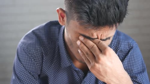 Man Rubbing Eyes in Discomfort, Close Up