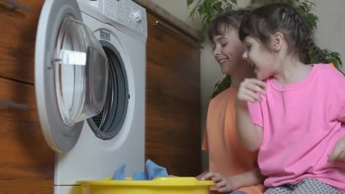 Kinder waschen Kleidung.