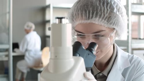 Woman Scientist Smiling in Laboratory with Microscope