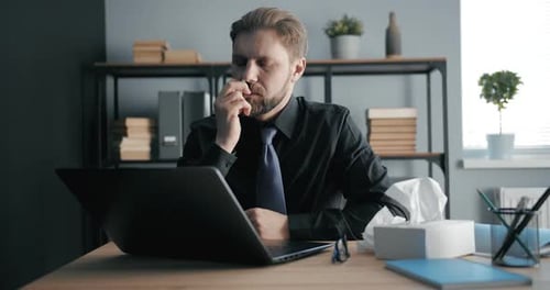 Homme souffrant d'un rhume au bureau