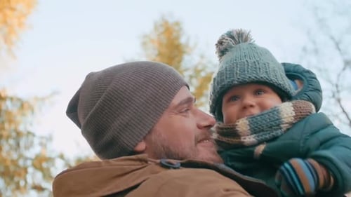 Dad Holds Young Child in Air Outdoors