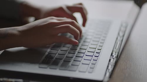 Typing Hands on Laptop in Office Environment