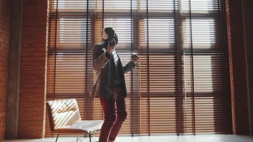 Man Dancing to Music in a Sunny Loft