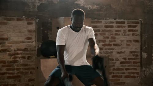 Sport man doing battle ropes exercise workout at gym