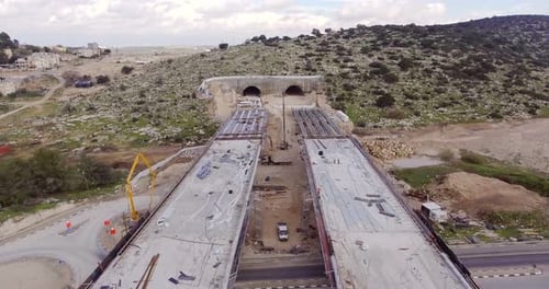Aerial footage of a large scale highway construction project with tunnels and bridges