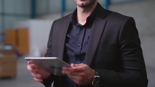 Factory Manager Using Tablet Computer in Warehouse or Factory