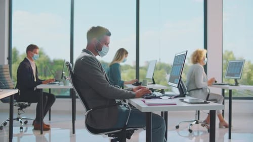 Masked Professionals Working in Bright Modern Office