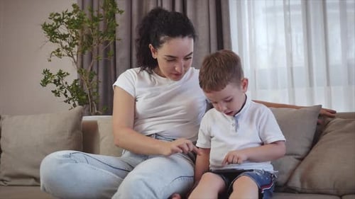 Woman and Boy Using Tablet Together on Couch