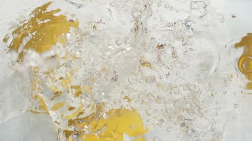 Lemons Splashing into Clear Liquid Water