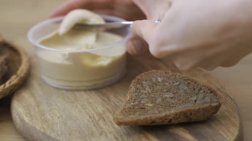 Spreading Hummus on Bread for Tasty Snack