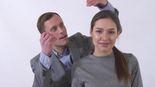Portrait of Genuine Man in Gray Suit Puts a Pendant on the Neck of a Girl Close Up