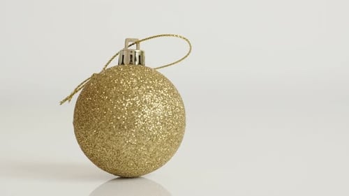 Golden bauble with sequins close-up 4K 2160p 30fps UltraHD tilting footage - Christmas ornament in