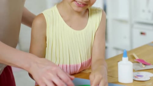 Happy Little Girl Making Paper Craft with Mom