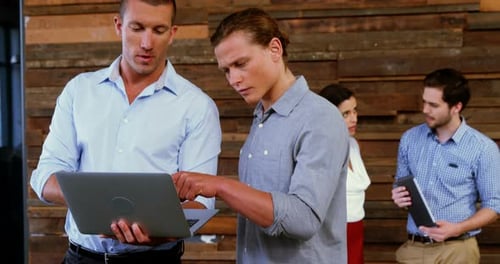Business Team Discussing Ideas on Laptop in Workplace