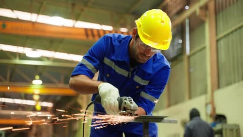Kaukasischer gutaussehender männlicher Industriearbeiter arbeitet in einer Produktionsstätte.