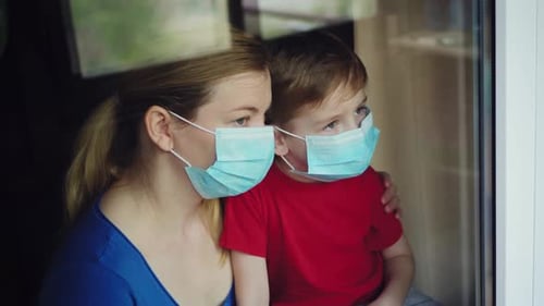 Masked Woman and Child Looking out the Window