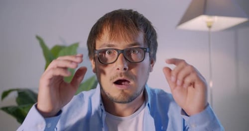 Shocked Man Takes Off Glasses in Surprise