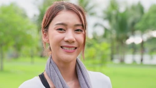 Portrait of Asian active sport woman stand with confidence after exercise outdoors at public park.