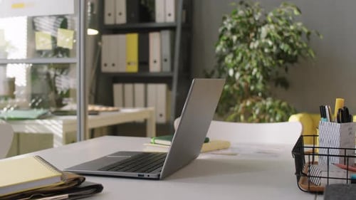 Laptop and Copybooks on Office Desk