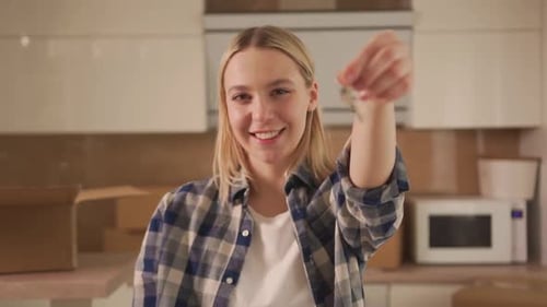 Young Woman Smiling Holding Keys in New Home