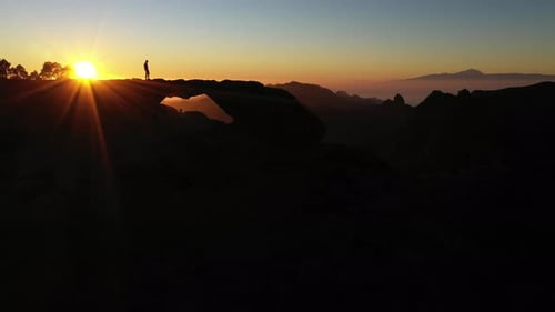 Majestic Mountain Sunrise with Silhouetted Figures