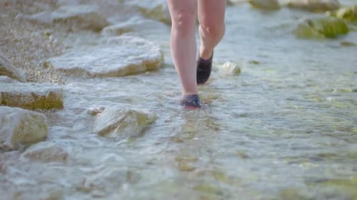 Child's Feet Walking Through Shallow Water on Beach